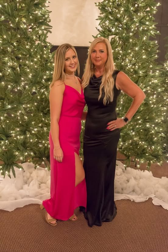 Two guests dressed up in front of the Christmas trees