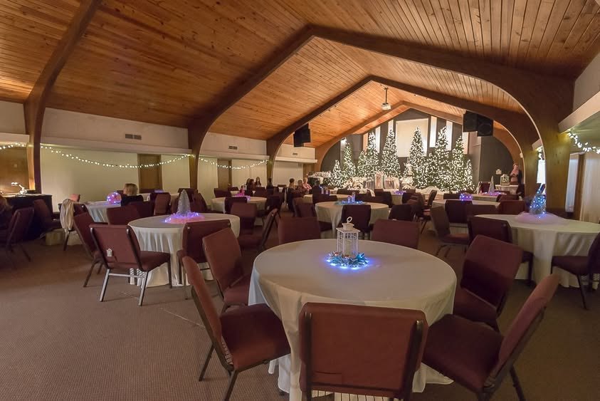 The room set with tables and Christmas trees before guests arrive